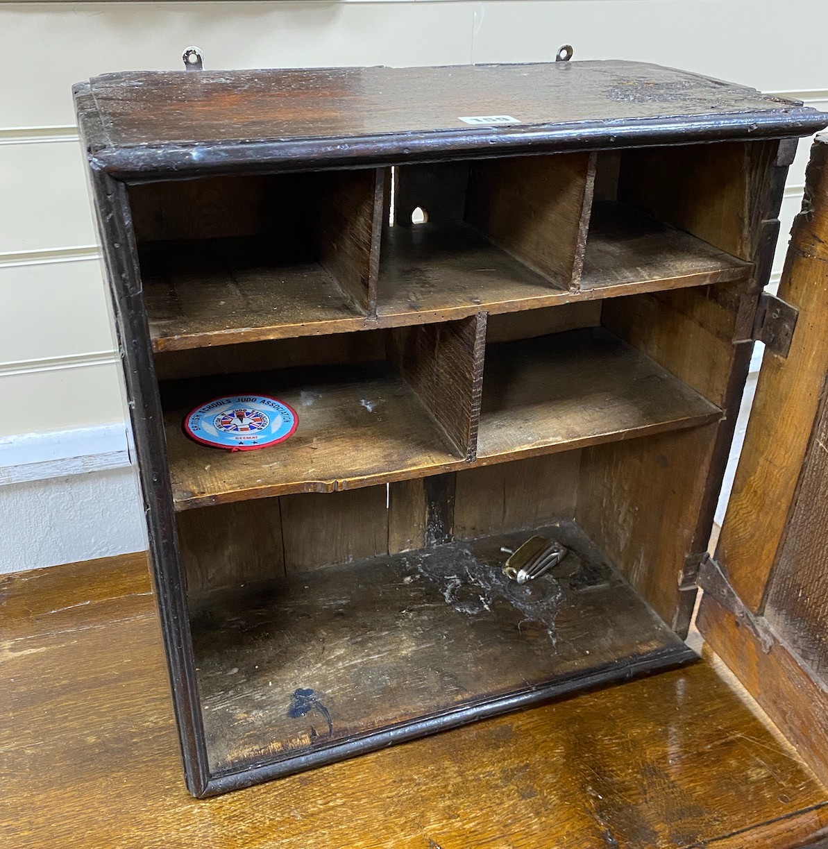 A Jacobean oak spice cupboard, enclosed by a geometric panelled door, width 45cm, depth 23cm, height 46cm